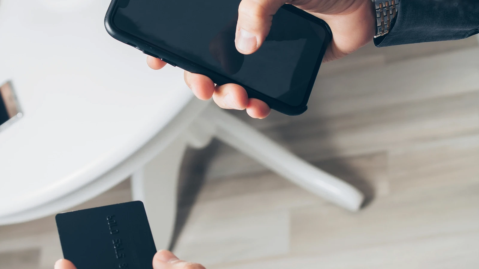 Persoană care verifică o plată cu telefonul și cardul