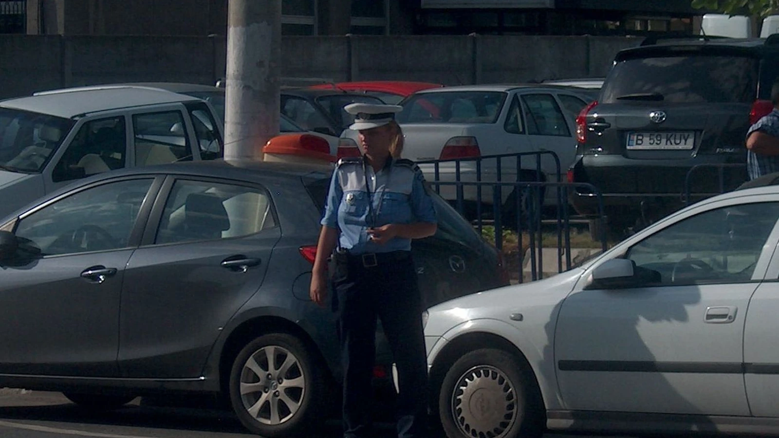 Polițist completând documente lângă un autoturism