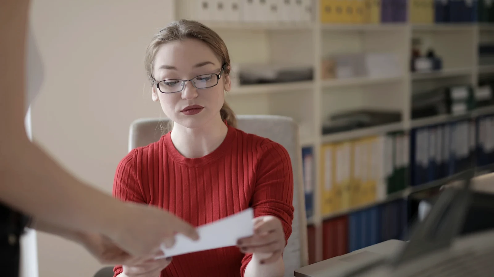 Salariată care primește și analizează documente într-un birou